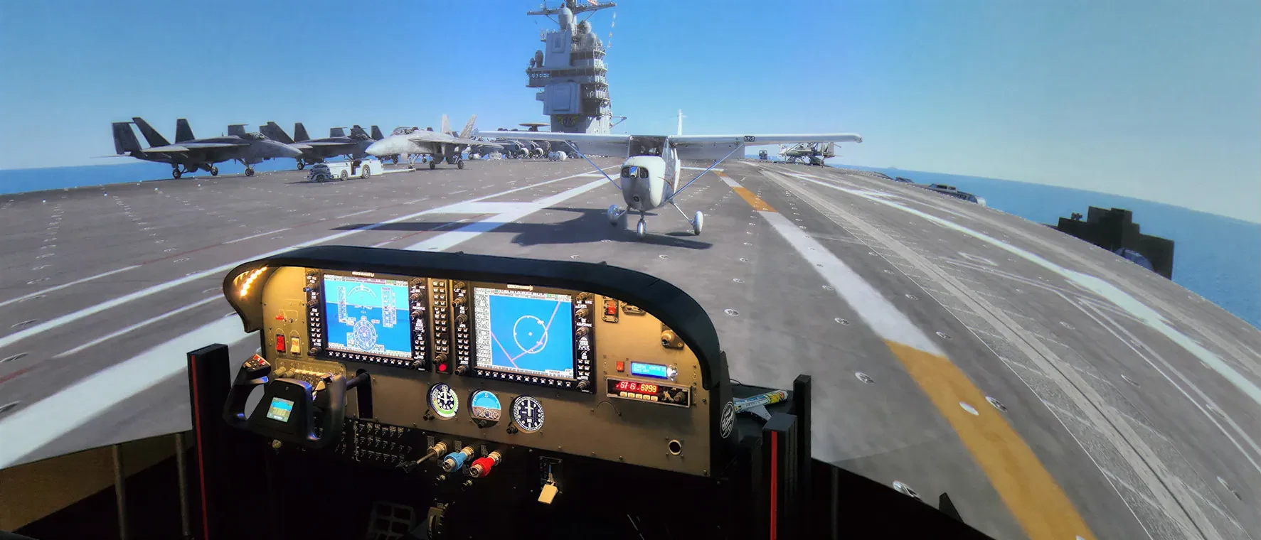 A guest flies a light aircraft simulator onto a carrier deck