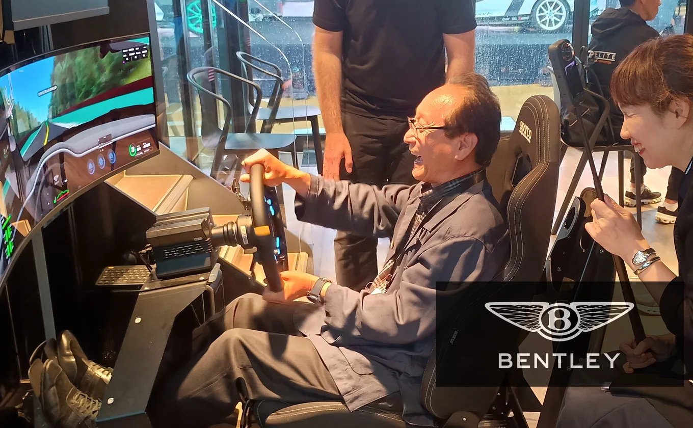 Two guests take turns at the wheel of a Bentley racing simulator