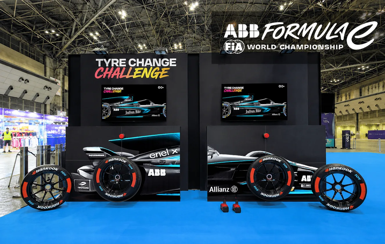 The ABB FIA Formula E Tyre Change Challenge — two pit-stop stations with full-size race cars