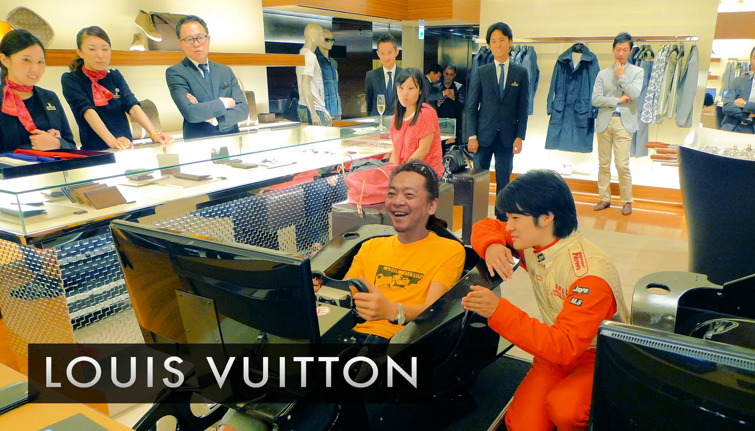 A racing simulator installed inside a Louis Vuitton boutique, with a driver in racing overalls