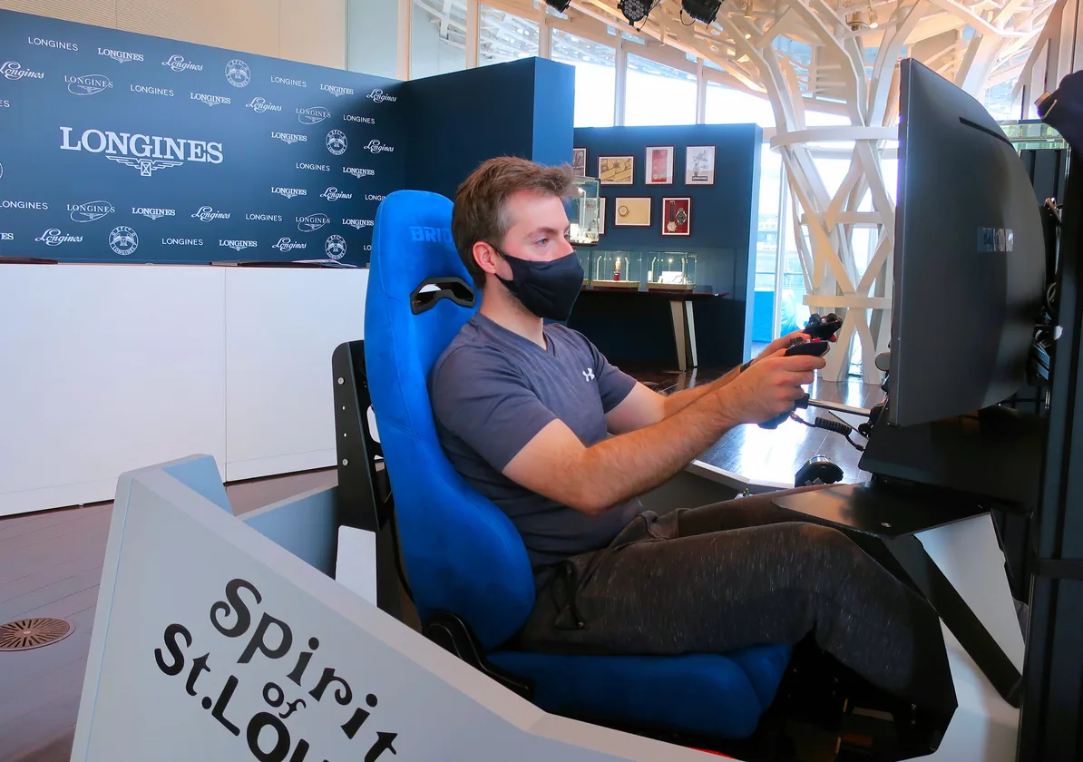 A guest races on a Longines-branded simulator at a boutique event