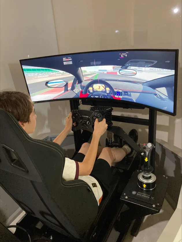 Un piloto al volante de un simulador privado con pantalla ultrapanorámica curva